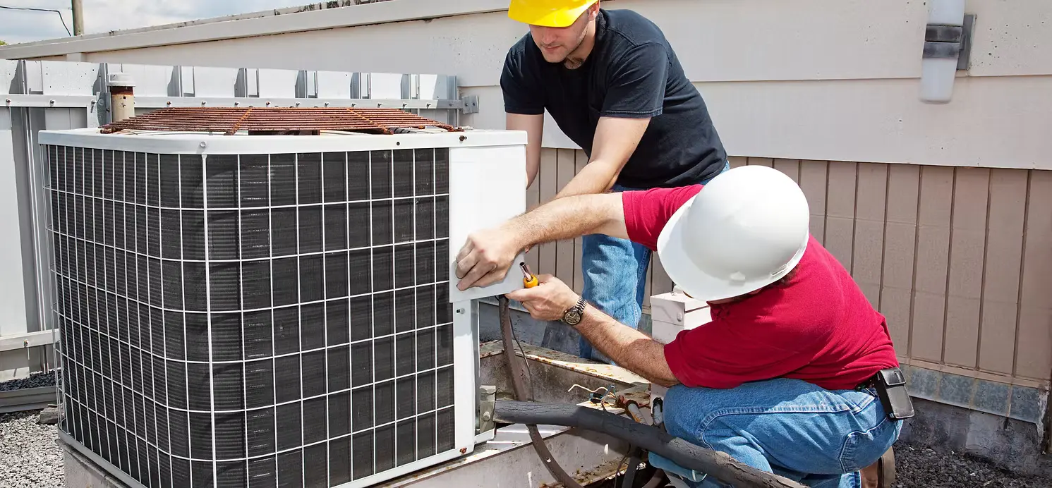 Técnico de HVAC dando servicio a una unidad de techo comercial